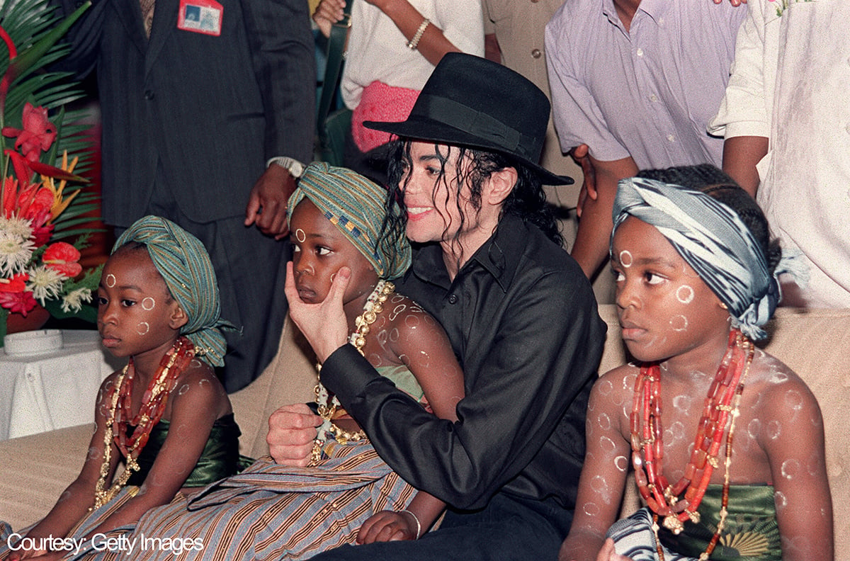 Michael Jackson sits with Ivory Coast children during a visit in 1992.