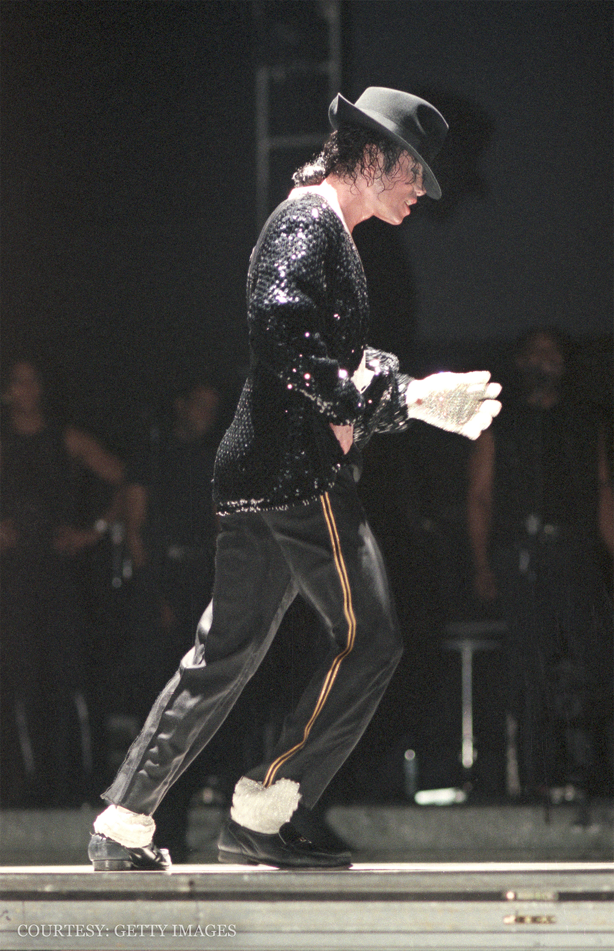 Michael Jackson moonwalks on stage during a concert tour.